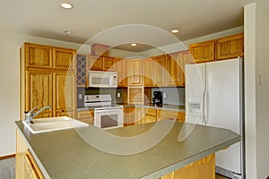 American wooden corner kitchen with gray counter tops.