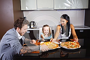 American young family eating pizza