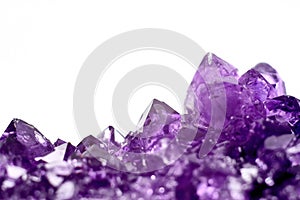 Amethyst crystals geode isolated on white.