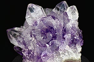 Amethyst druse on a dark background close up. Cluster of lilac crystals