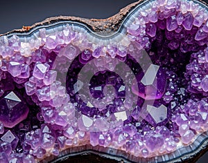 Amethyst geode marble with purple crystal clusters on a black base, showcasing a gemological cross-section texture in macro photo