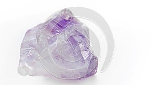 Amethyst macro photography. Purple translucent stone on a white background. Massage of the face and body with gems. The use of