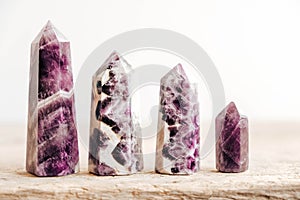 Amethyst polished crystal point on a wooden table. Copy, empty space for text