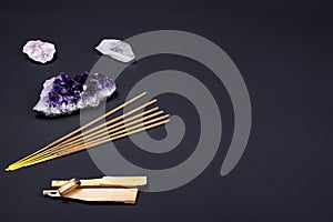 Amethyst and quartz crystal stones, palo santo wood, Aromatic sticks on black background.