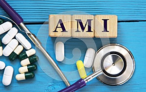 AMI - acronym on wooden cubes on a blue background with a stethoscope and tablets