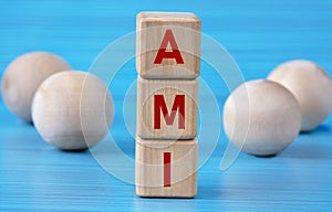 AMI - acronym on wooden cubes on a blue background with wooden round balls