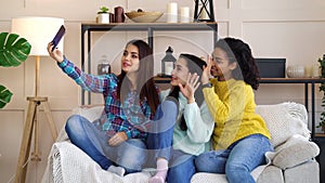 Amiable multiracial girls live streaming from home using smartphone