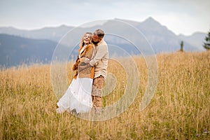 Amidst nature, the couple embraces in a tender embrace, gazing at the splendid landscape, with their hearts beating in unison