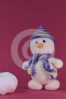 Soft DIY toy made of natural cotton and wool. Crocheted, handmade art. Amigurumi one small white snowman with orange