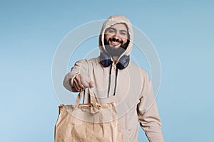 Amiling arab man giving paper bag