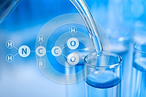 Amino Acids chemical formula, illustration. Dripping reagent into test tube with liquid sample, closeup