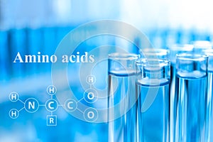 Amino Acids chemical formula. Test tubes with liquid samples for analysis in laboratory, closeup