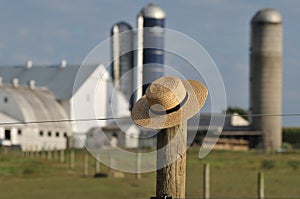 Amish farm with straw hat over fence post