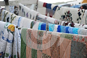 Amish handmade quilts hanging on line