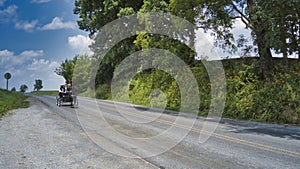 Amish Open Horse and Buggy Approaching With a Couple and Daughter in it