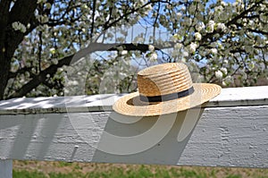 Amish straw hat on a white fence