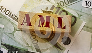 AML abbreviation stands for Anti Money laundering, on wooden blocks on 100 euro banknotes. No corruption concept