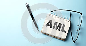 AML text written on a notepad on the blue background