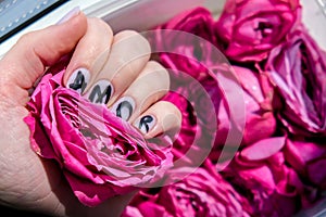 AMOR word on nails manicure hold Pink rose flower. Minimal flat lay nature. Female hand. Love