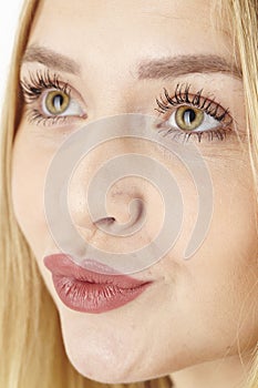 Amorous attractive blond woman purses her lips