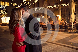 Amorous couple kissing on Christmastime