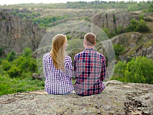 Amorous couple relaxing in nature. Casual man and woman on a natural background. Student traveling concept. Copy space.