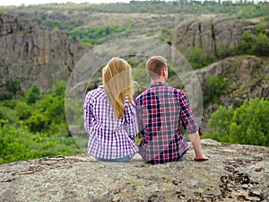 Amorous couple relaxing in nature. Casual man and woman on a natural background. Student traveling concept. Copy space.