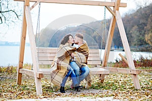 Amorous couple on romantic date on swings outdoor