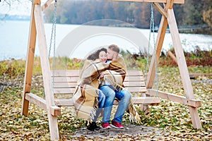 Amorous couple on romantic date on swings outdoor