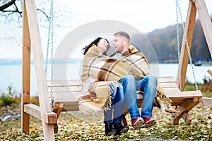 Amorous couple on romantic date on swings outdoor