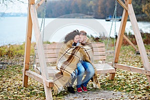 Amorous couple on romantic date on swings outdoor