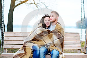 Amorous couple on romantic date on swings outdoor