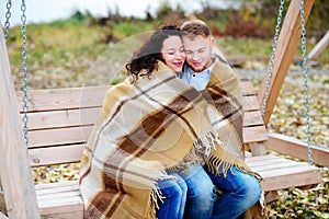 Amorous couple on romantic date on swings outdoor