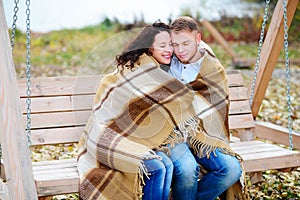 Amorous couple on romantic date on swings outdoor