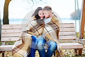 Amorous couple on romantic date on swings outdoor