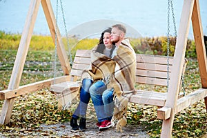 Amorous couple on romantic date on swings outdoor