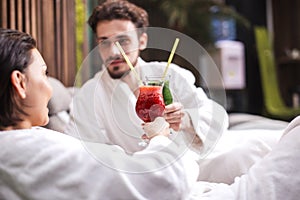 Amorous couple is toasting with glasses of juice.