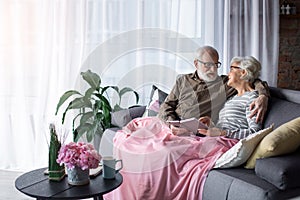 Amorous old man and woman resting at living room