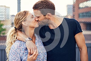 Amorous young couple enjoy a romantic kiss