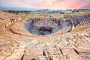 Amphitheater in ancient city of Hierapolis under dramatic pink sky