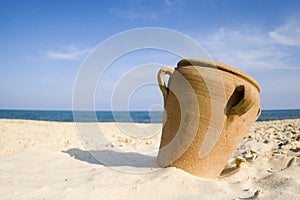 Amphora on sand beach photo