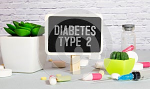 Ampoules, pills, stethoscope, thermometer, tablet with DIABETES TYPE 2 text on desktop