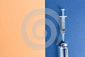 Ampoules with a vaccine and a syringe on a blue background.