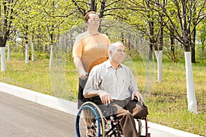 Amputee being taken for a walk in a wheelchair