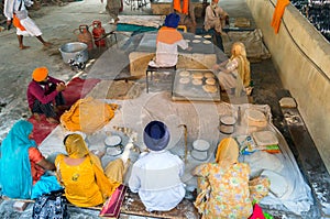 Amritsar, India - November 21, 2011: Unknown Indian people cook national bread for a free meal for pilgrims. Golden Temple in