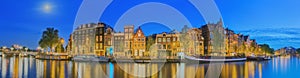 Amstel river, canals and night view of beautiful Amsterdam city. Netherlands.