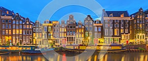 Amstel river, canals and night view of beautiful Amsterdam city. Netherlands.