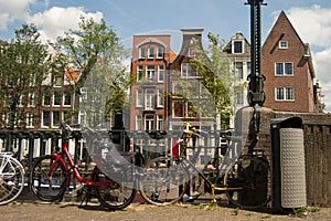 Amsterdam bikes at sidewalk with houses on background