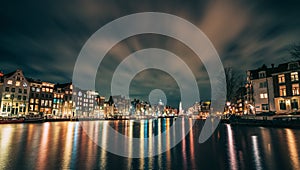 Amsterdam canal, Amstel river with city illumination reflection, Netherlands, Dutch city at night