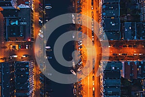 Amsterdam canal, old dancing houses, river Amstel and illuminated streets, aerial top view at night, drone photo